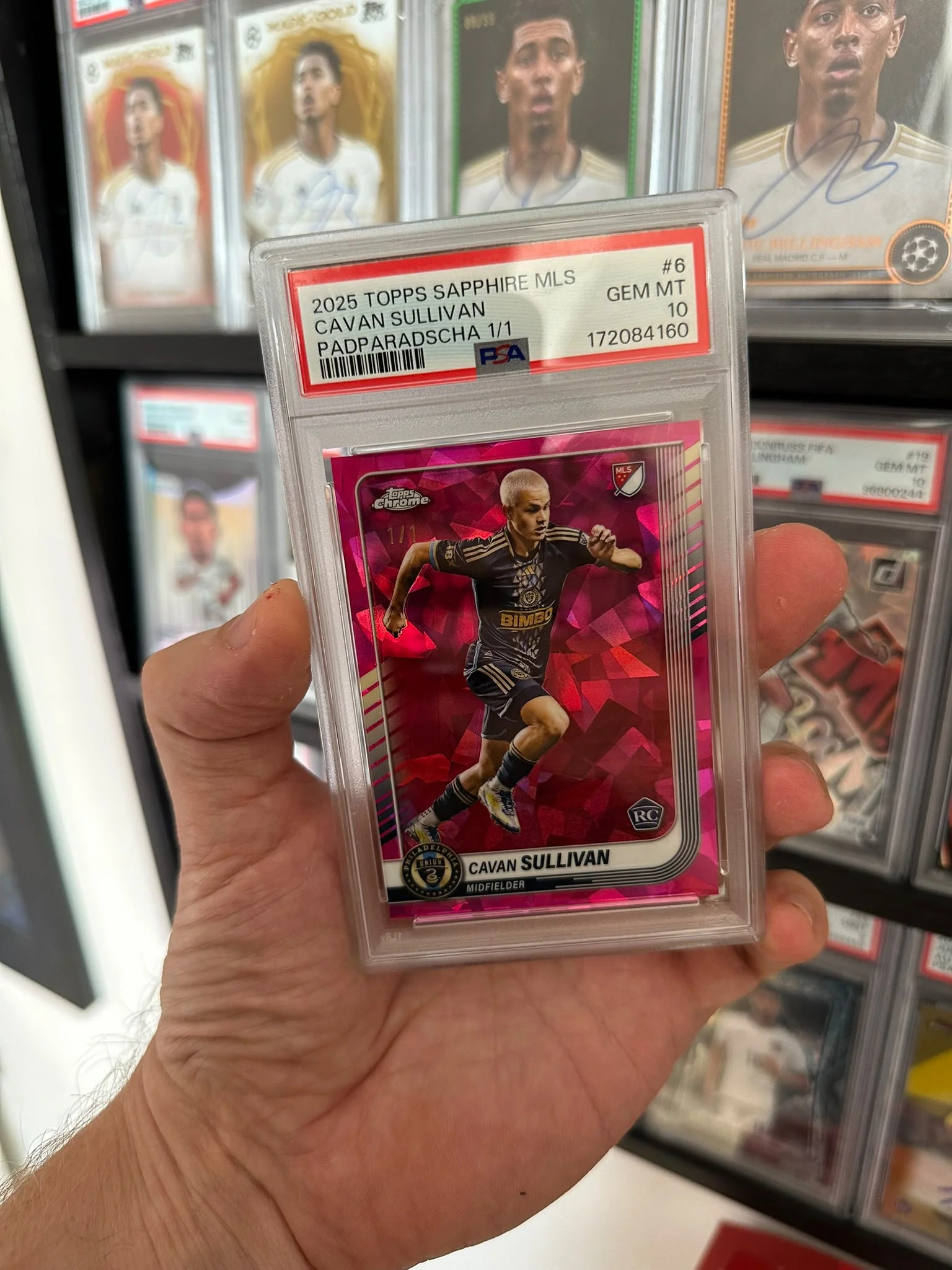 Cavan Sullivan Padparadscha 1/1 PSA 10 held in front of the collection